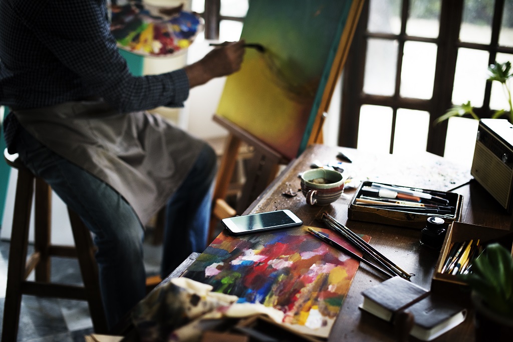 Artist painting artwork at workspace